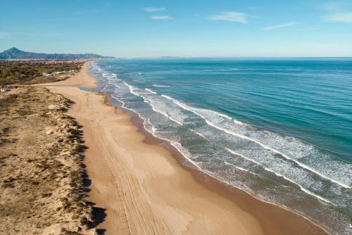 an aerial view of a beach with the ocean at Las Dunas 215 - by Welcomely in Oliva
