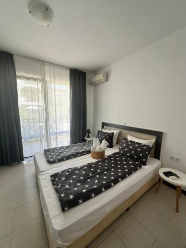 a bedroom with two beds with black and white sheets at Апартаменти Литорал in Chernomorets