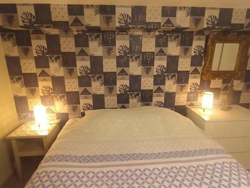 a bedroom with a bed and two tables with lamps at Chez Marianne in Hotton