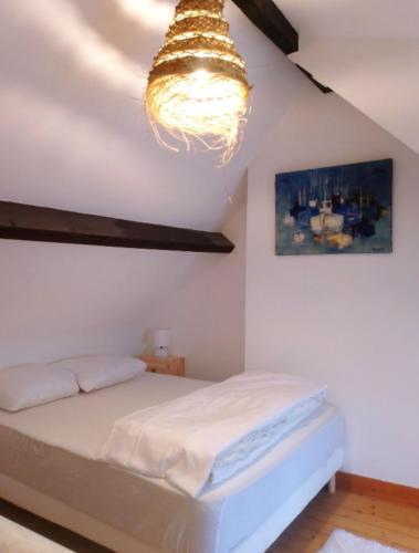 a bedroom with a bed and a chandelier at Village du Manémeur in Quiberon