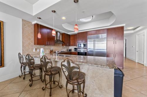 a kitchen with a large island with bar stools at Turquoise Place 408C in Orange Beach