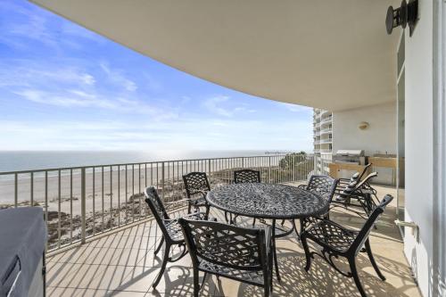 a balcony with a table and chairs and the ocean at Turquoise Place 408C in Orange Beach