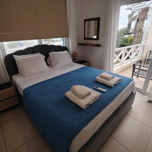 a bedroom with a bed with towels on it at Horizon Bliss at Coral Bay in Peyia
