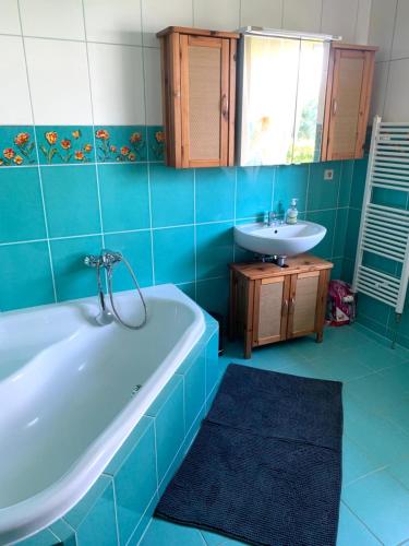 a blue bathroom with a tub and a sink at Pension Horn in Schkopau