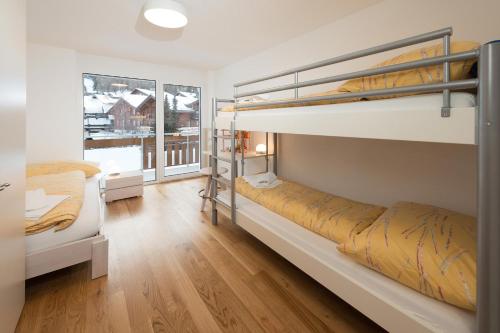 a bedroom with two bunk beds and a window at Millegga Grächen in Grächen