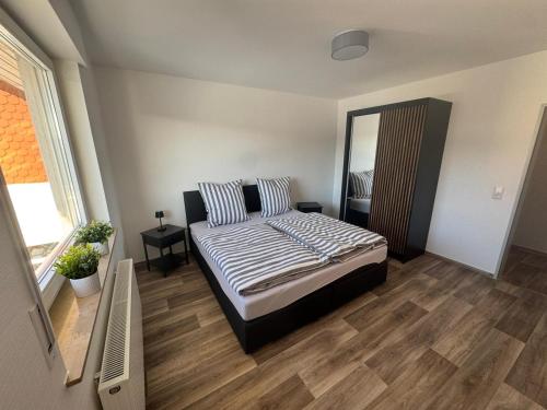 a bedroom with a bed and a large mirror at Wohnung bei den Drei Gleichen #S in Wandersleben