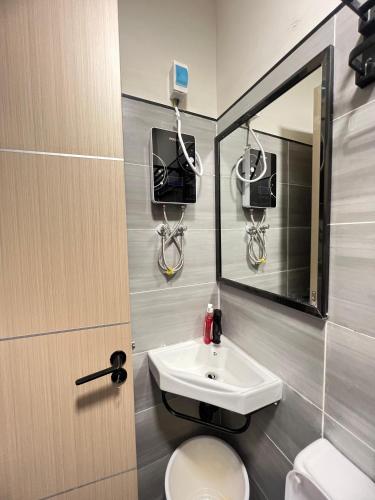 a bathroom with a sink and a toilet and a mirror at Studio near JKIA and SGR Syokimau in Nairobi