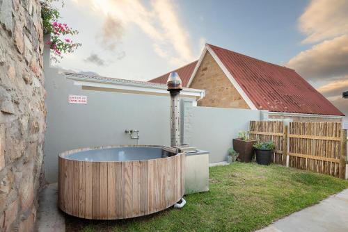 a bath tub in a yard next to a house at Unwinding Mossel bay in Mossel Bay