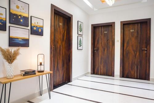 a hallway with two wooden doors and a table at FabHotel Lotus Blue in Bhopal