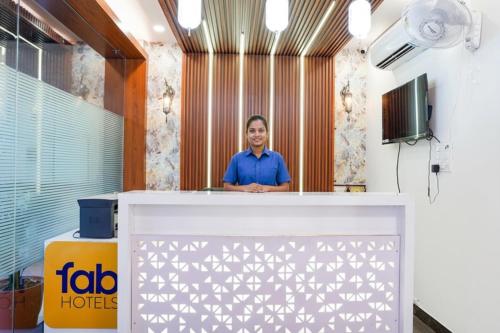 a man standing behind a reception desk at FabHotel Lotus Blue in Bhopal