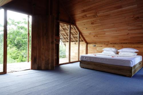 a bedroom with a bed in a wooden house at Mamba Yala in Tissamaharama