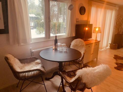 a dining room with a table and chairs and a window at 'Back to Nature' Chalet Bospark Ijsselheide Hattemerbroek Veluwe in Hattemerbroek