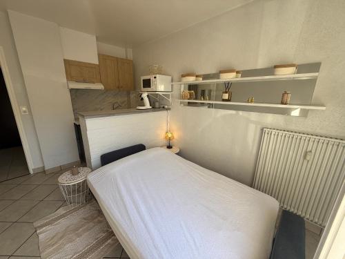 a small kitchen with a bed in a room at Studio moderne au cœur de Compiègne in Compiègne