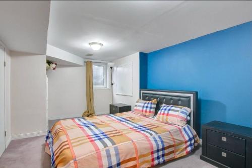a bedroom with a bed and a blue wall at A very peaceful home in Oshawa