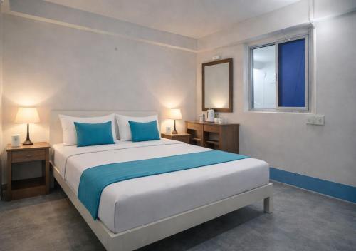 a bedroom with a large bed with blue pillows at Mahadev Guest House in Deoghar