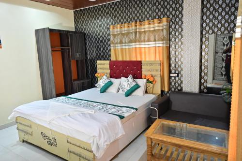 a bedroom with a large bed and a table at Royal Mac Palace in Motīhāri