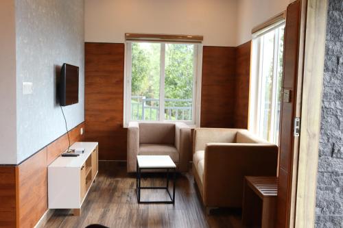 a living room with a couch and a window at Ramee Wolkenburg Resort & Spa, Munnar in Munnar