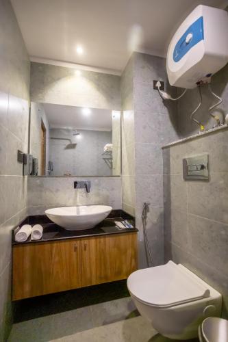 a bathroom with a sink and a toilet and a mirror at Hotel Eleven in Kathmandu