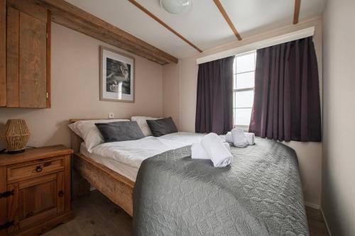 a bedroom with a large bed and a window at 42, Cottage - Oisterwijk - Nature in Oisterwijk