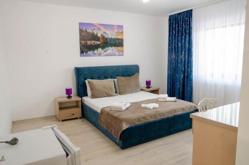 a bedroom with a bed with a blue headboard at Casa Georgia in Târgu Ocna