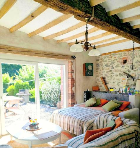 a bedroom with a bed and a table and a patio at Grand gîte champêtre ! LA SOURCE DE NOS RACINES - CORPS DE FERME AU COEUR DU PARC NATUREL DE L'AVESNOIS in Beaufort