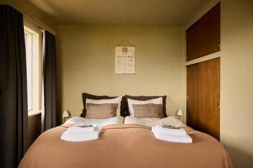 a bedroom with a large bed with towels on it at Eyri Farm in Kjósahreppur