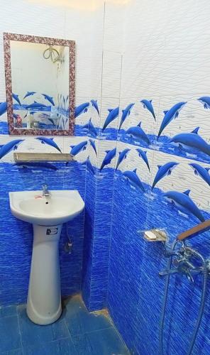 a bathroom with a sink and a blue tiled wall at Apple Zone Home stay in Banjār