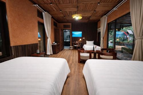 a bedroom with two beds and a desk and a television at Tam Cốc Valley Eco Resort in Ninh Binh