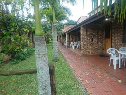 a brick building with a patio with tables and chairs at Flamboyant Apartments in St Lucia