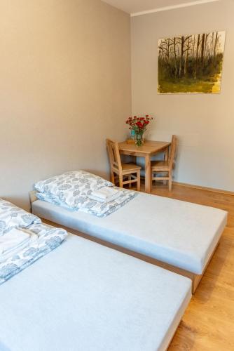 a room with two beds and a table with a vase of flowers at Noclegi GCK Biała in Biała
