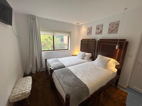 a bedroom with a large bed and a window at Bela vista AL in Paredes de Coura