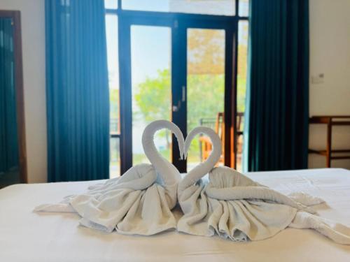 two towelsrendered to look like swans sitting on a bed at Cormorant Bath in Netolpitiya