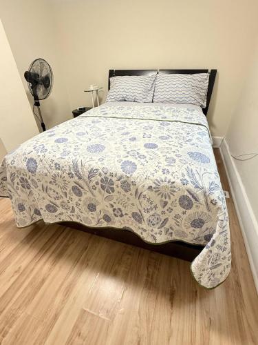 a bed with a blue and white comforter in a bedroom at Cozy Duplex 2nd floor suite in Winnipeg