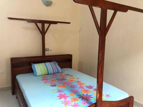 a bedroom with a wooden bed with a wooden canopy at Mariagletta Cozy Villa in Abomey-Calavi