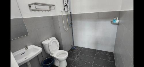 a small bathroom with a toilet and a sink at Spacious 4 bedroom homestay in Mersing