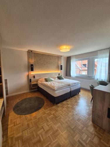 a bedroom with a bed and a large window at Hotel Restaurant Brinckwirth in Ochtrup