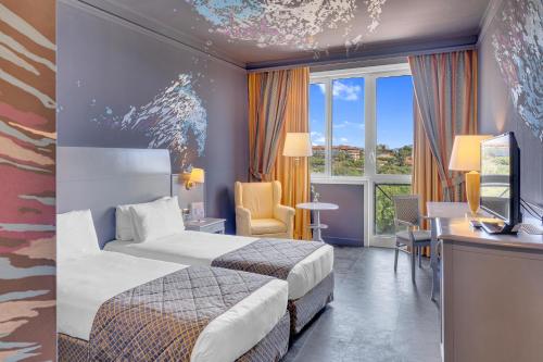 a hotel room with two beds and a desk at Hotel Roma Aurelia Antica in Rome