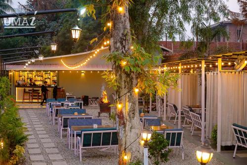 a patio with tables and chairs and lights at Umai Garden Resort in Jogīkuti