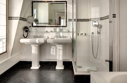a white bathroom with two sinks and a shower at Hôtel Pavillon Henri IV in Saint-Germain-en-Laye
