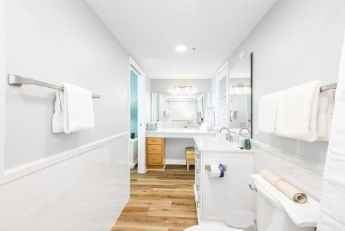 a white bathroom with a sink and a toilet at Landmark Holiday Beach in Panama City Beach
