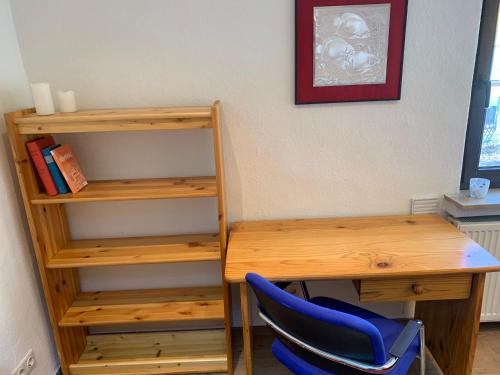 a desk and a chair next to a book shelf at Business Apartment Herne-Wanne in Herne