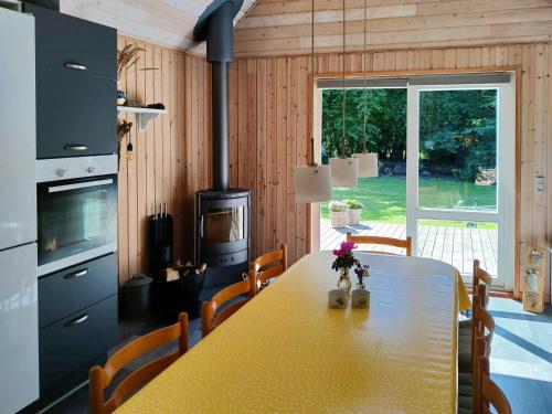 a dining room with a table and a fireplace at Home Near Beach With Wilderness Bath in Sindrup