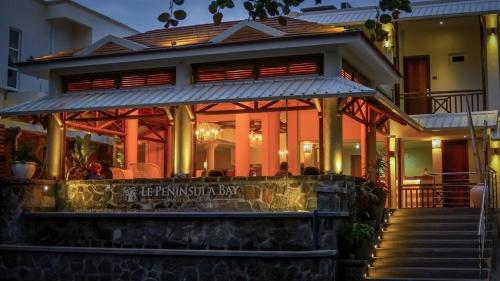 a building with a restaurant in front of it at Le Peninsula Bay Beach Resort & Spa in Blue Bay