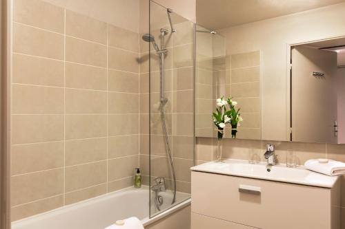 une salle de bain avec une baignoire, un lavabo et une douche dans l'établissement Citadines Prado Chanot Marseille, à Marseille