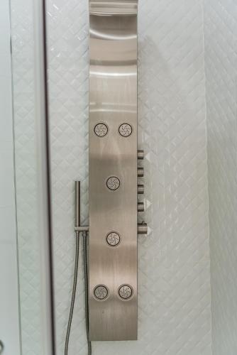 a metal wall in a bathroom with clocks on it at Villa Belle Azure by PikHost in Dhërmi
