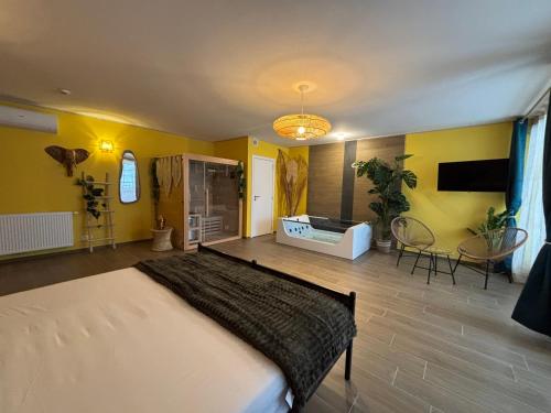 a bedroom with a large bed and yellow walls at Le Bovary Hotel Suite Safari in Héron