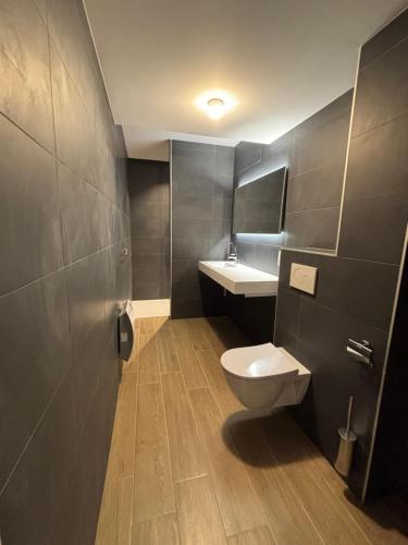 a bathroom with a toilet and a sink at Le Bovary Hotel Suite Safari in Héron