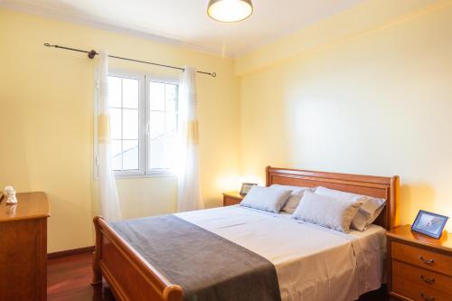 a bedroom with a large bed and a window at Villa Lobos Flat 1 in Câmara de Lobos