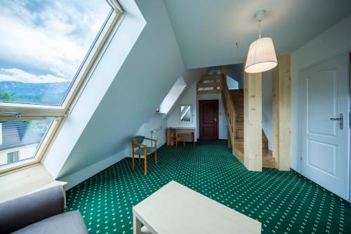 an attic room with a staircase and a window at Willa Excelsior in Zakopane