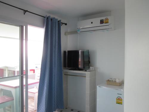 a small room with a tv and a curtain at Toonja Kohlarn in Ko Larn